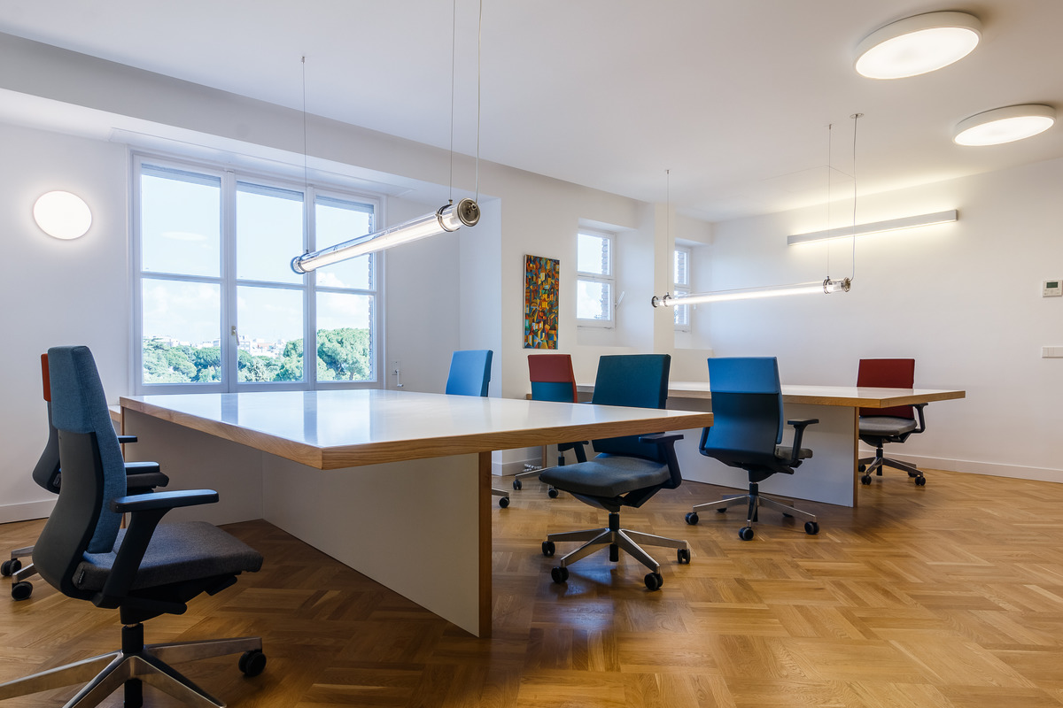Large tables with T-shaped bases can be used for single workspaces or project teams. The Neos office chairs (design: wiege) have different colored upholstery as splashes of color and to indicate who is sitting where.