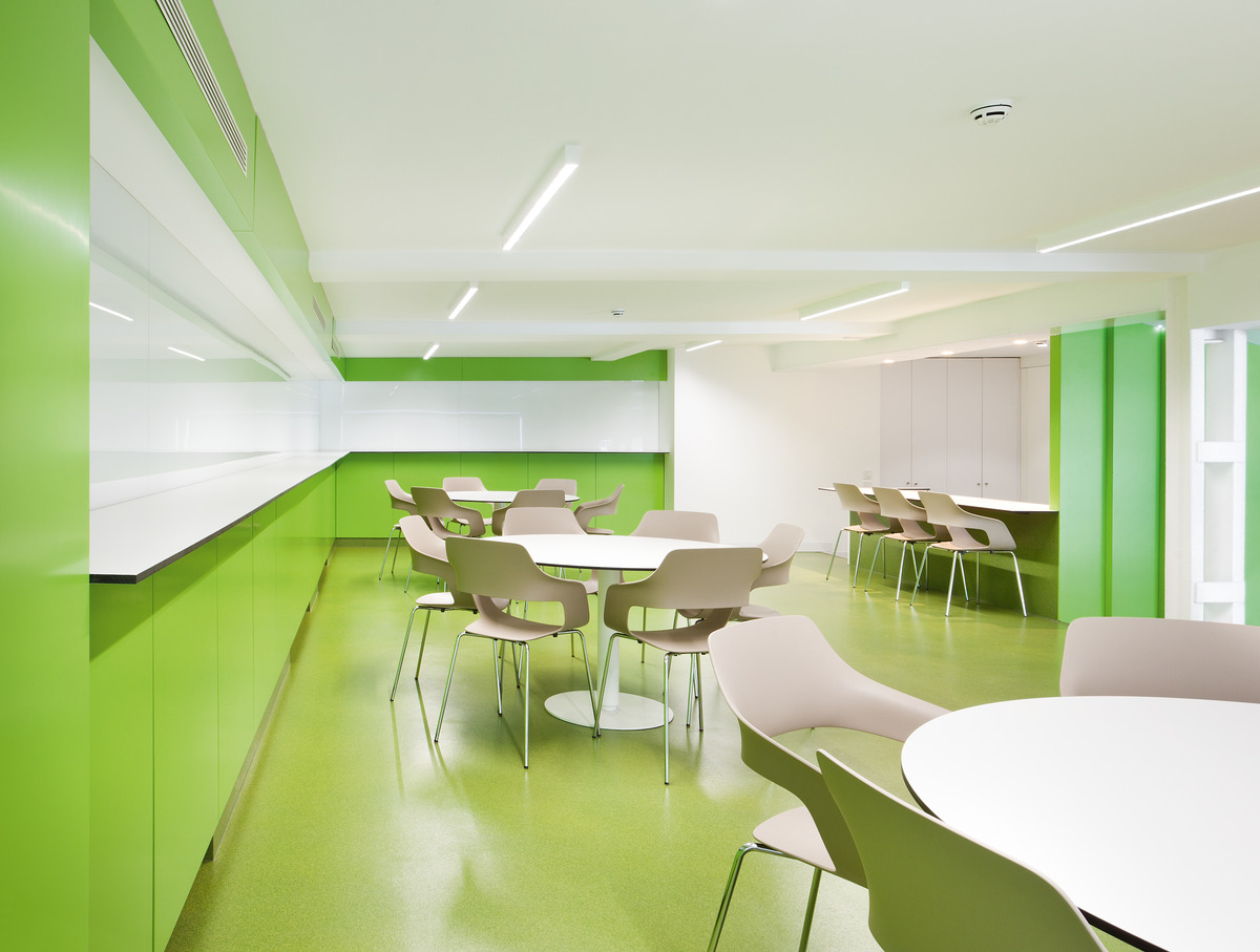 Die großzügige, in Knallgrün gehaltene Cafeteria lädt zu entspannten Pausen ein. Sie ist mit pflegeleichten, stapelbaren Occo-Sesseln in Beige ausgestattet (Design: jehs+laub).