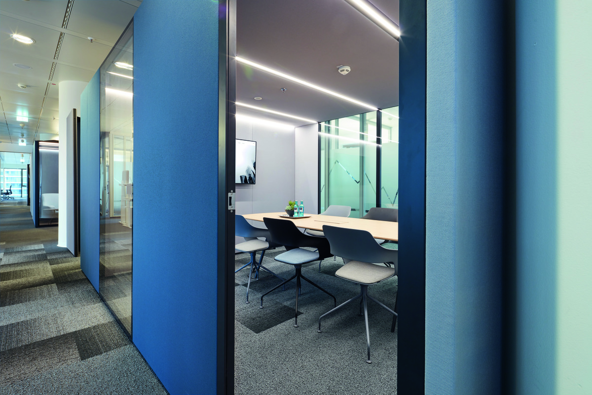 Glass walls provide daylight to the conference rooms on the inside. The colors of the shells and seat covers on the swivel-mounted Occo conference chairs (design: jehs+laub) differ to match the natural mix of colors in the flooring.
